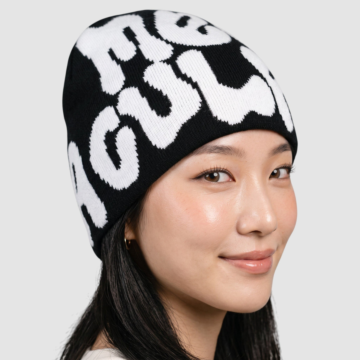 Y2K STUDIO black skullie beanie with white graffiti bubble lettering worn by a model
