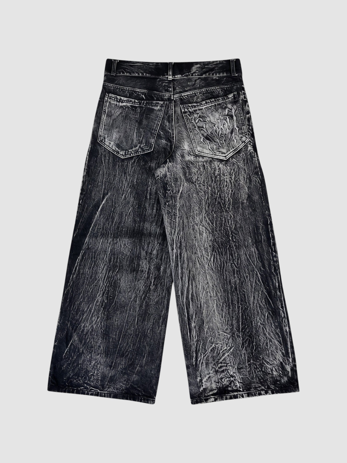 Y2K Studio wide-leg acid wash black denim jeans with raw edge spiderweb appliqué detail on the back pockets