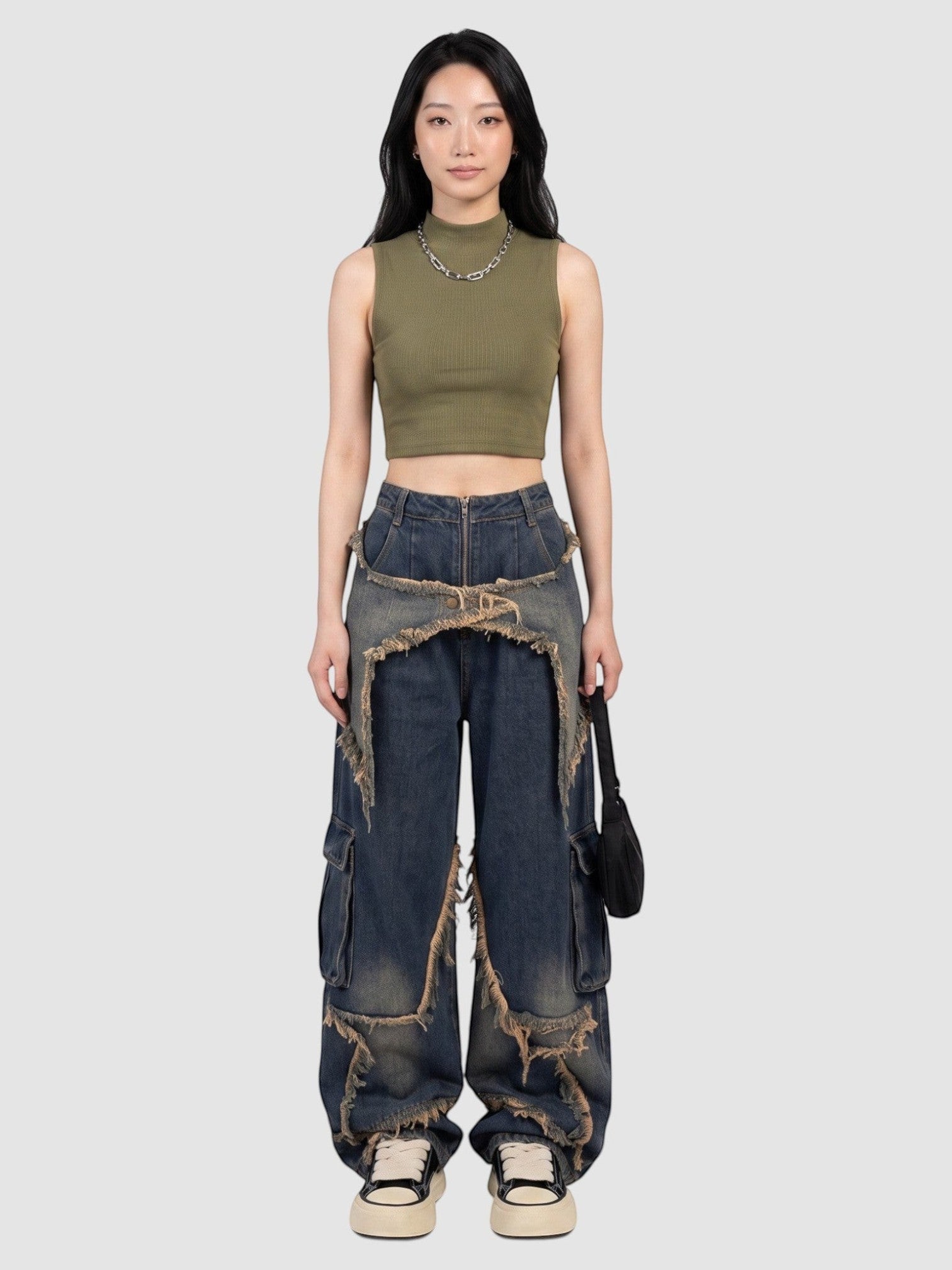 Model wearing Y2K Studio baggy indigo cargo jeans with frayed denim overlays and a high-waisted fit