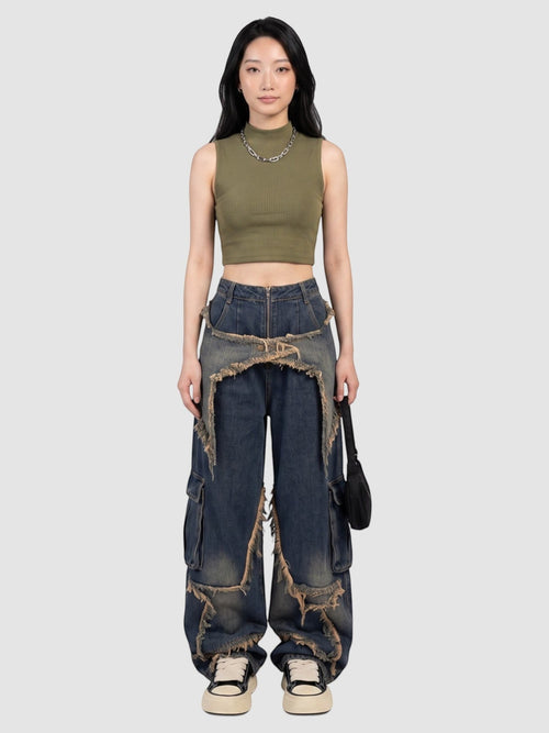 Model wearing Y2K Studio baggy indigo cargo jeans with frayed denim overlays and a high-waisted fit