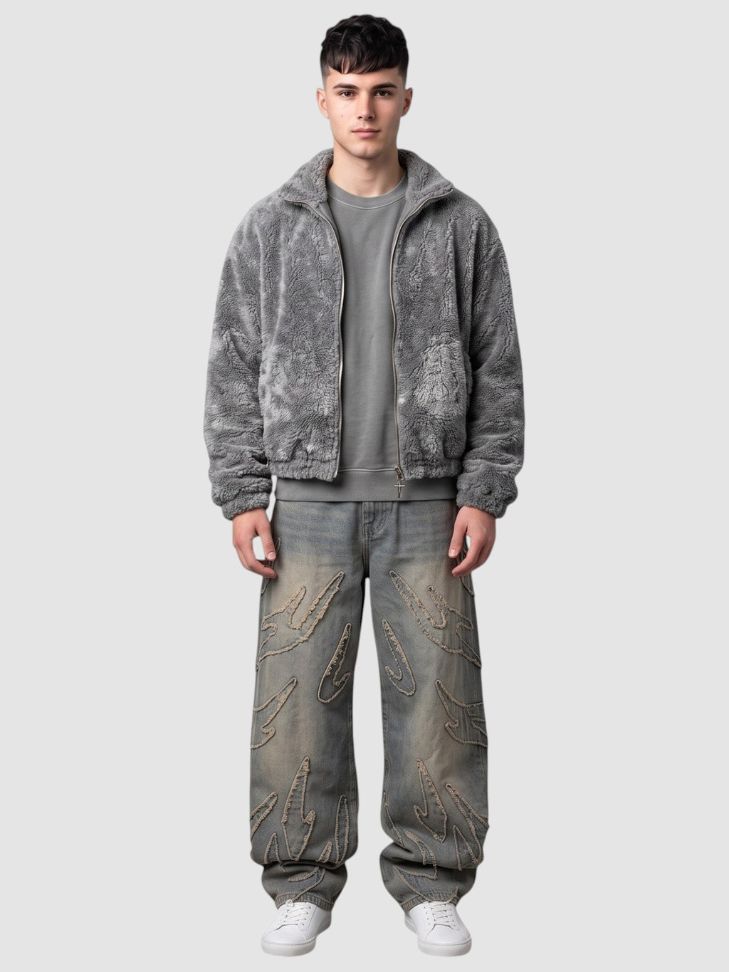 Y2K Studio baggy grey denim jeans featuring raw-edge flame appliqués, worn by a model with a grey fleece jacket.