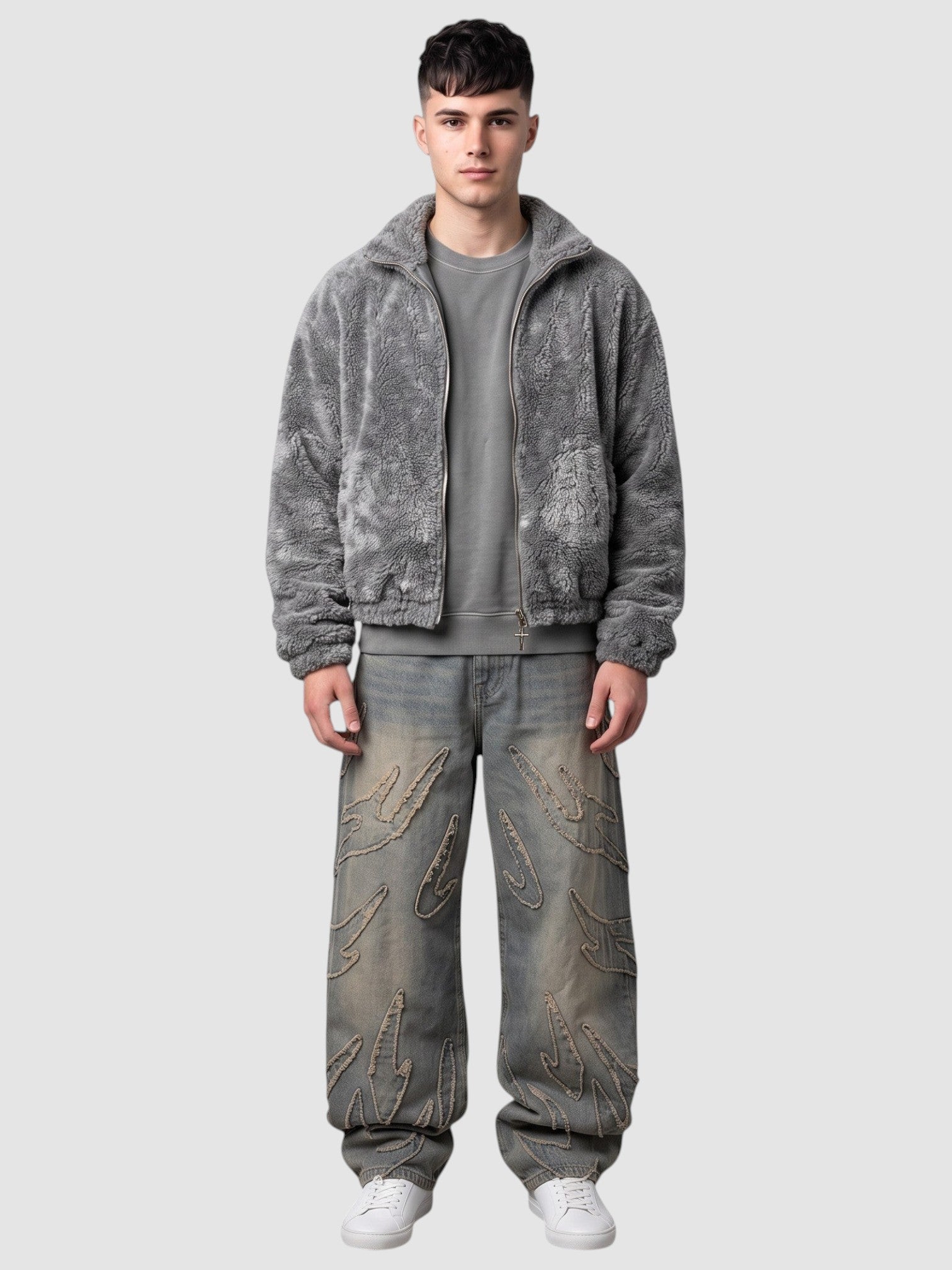Y2K Studio baggy grey denim jeans featuring raw-edge flame appliqués, worn by a model with a grey fleece jacket.