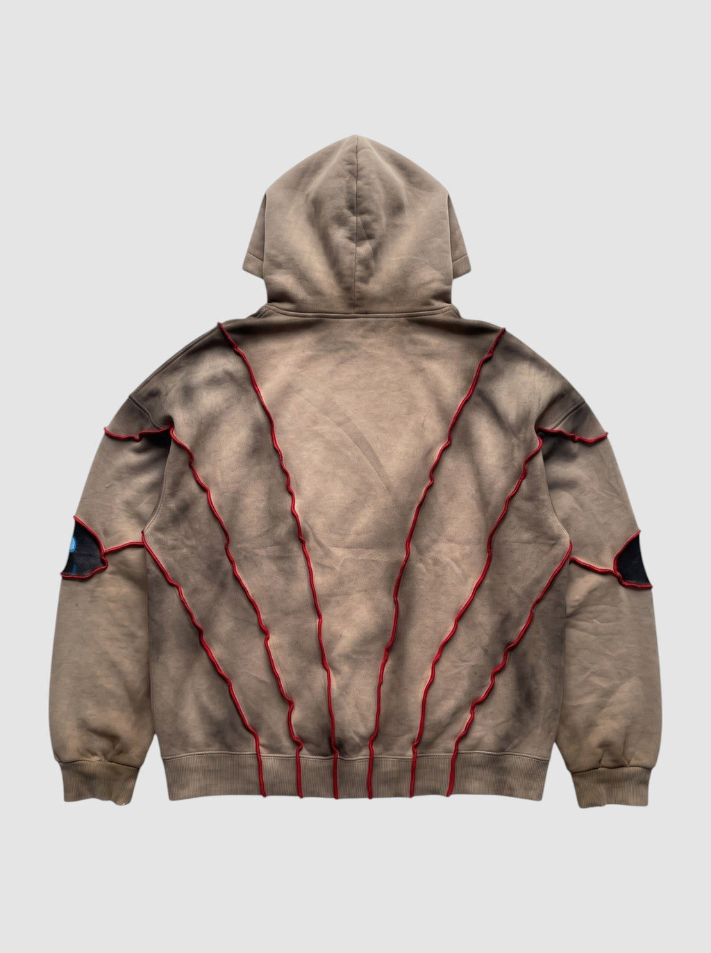 Back view of Y2K Studio oversized beige faded hoodie with red raised seams and patchwork eye details