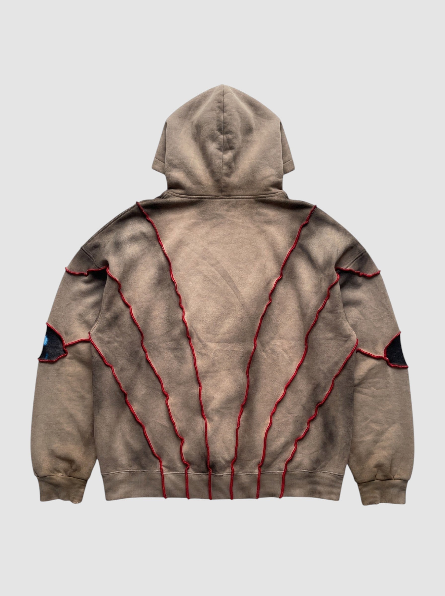 Back view of Y2K Studio oversized beige faded hoodie with red raised seams and patchwork eye details