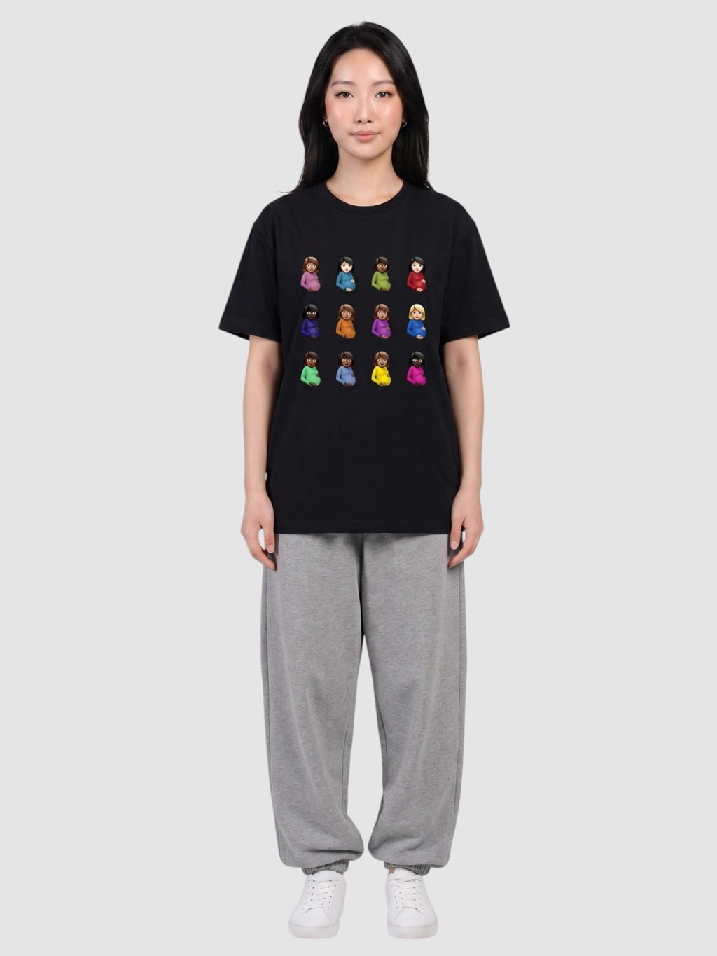 Y2K Studio black polyester t-shirt with a grid of colorful emoji prints worn by a woman with grey sweatpants