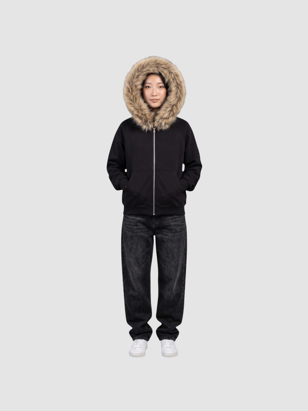 Model wearing a Y2K Studio black zip-up hoodie with a large beige faux fur hood trim and ribbed cuffs.