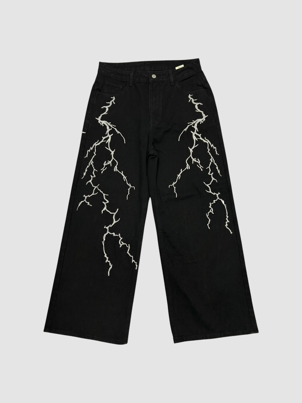 Y2K Studio black wide-leg denim jeans featuring white embroidered lightning bolt patterns on both legs.