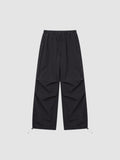 Y2K STUDIO black parachute pants with high elastic waist, adjustable drawstring cuffs, and pleated knee detailing.