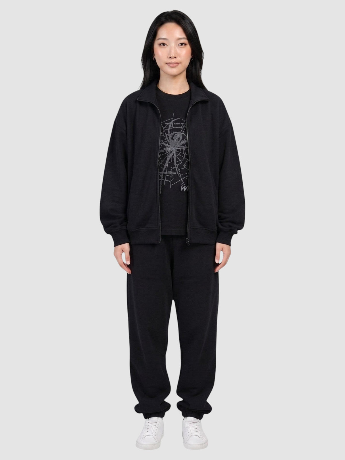 Y2K Studio black oversized t-shirt with dark grey spider web print worn by a model in a matching tracksuit
