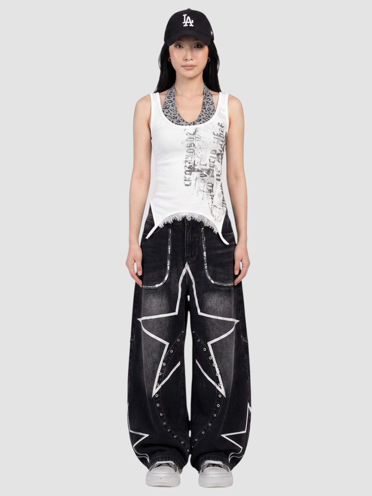 Y2K STUDIO baggy black wide leg jeans with white star prints and metal eyelets worn low-rise by a model