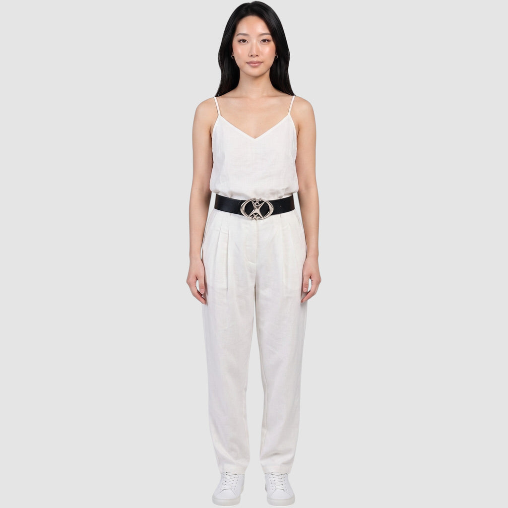 Y2K Studio black faux leather belt with a silver star-shaped buckle worn by a model in a white linen outfit.