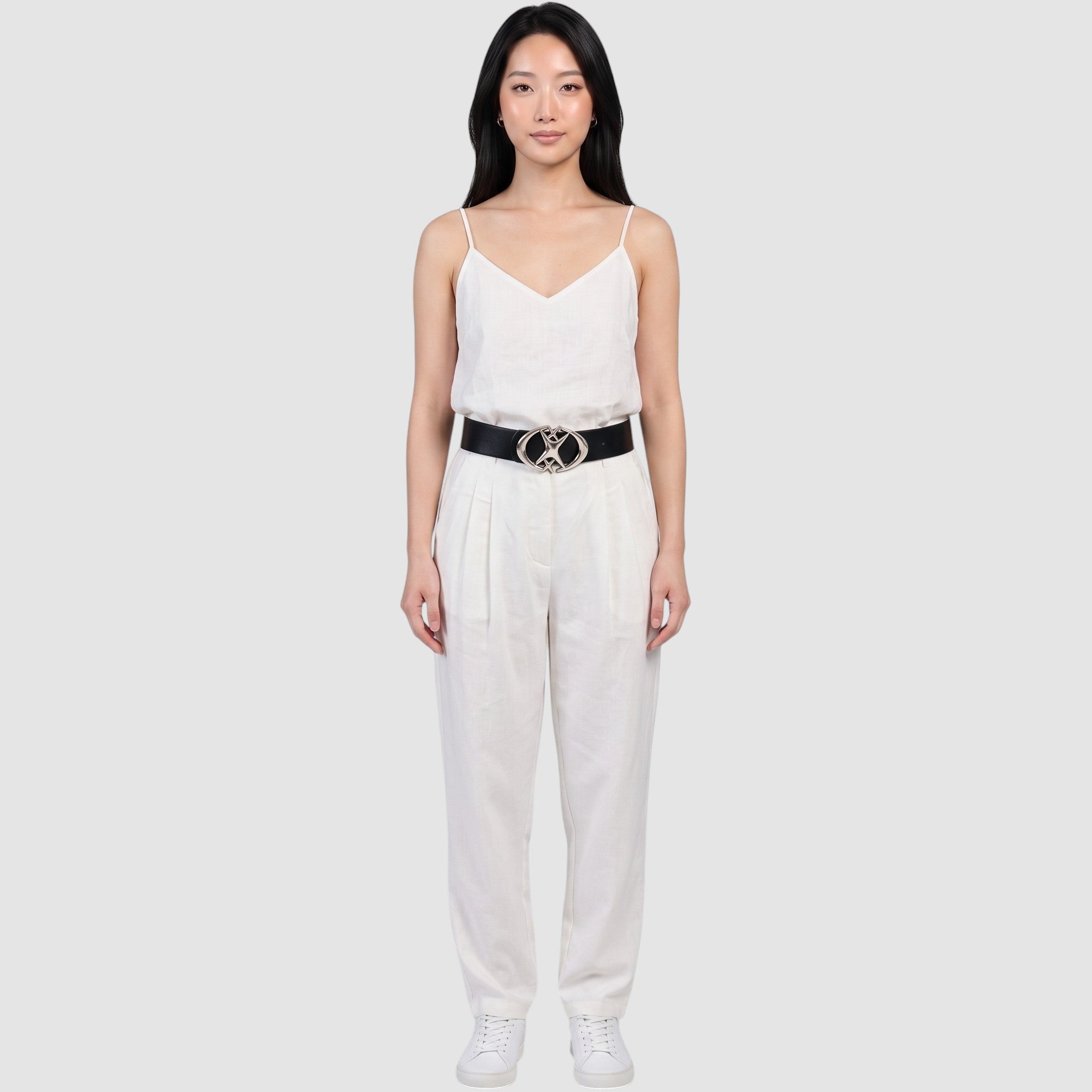Y2K Studio black faux leather belt with a silver star-shaped buckle worn by a model in a white linen outfit.