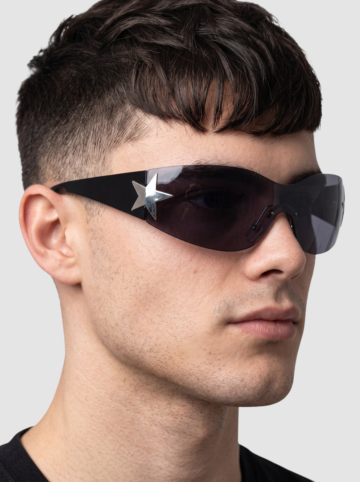 Y2K Studio black Y2K star mask sunglasses with a single-piece wraparound lens and silver star detail on the temple.