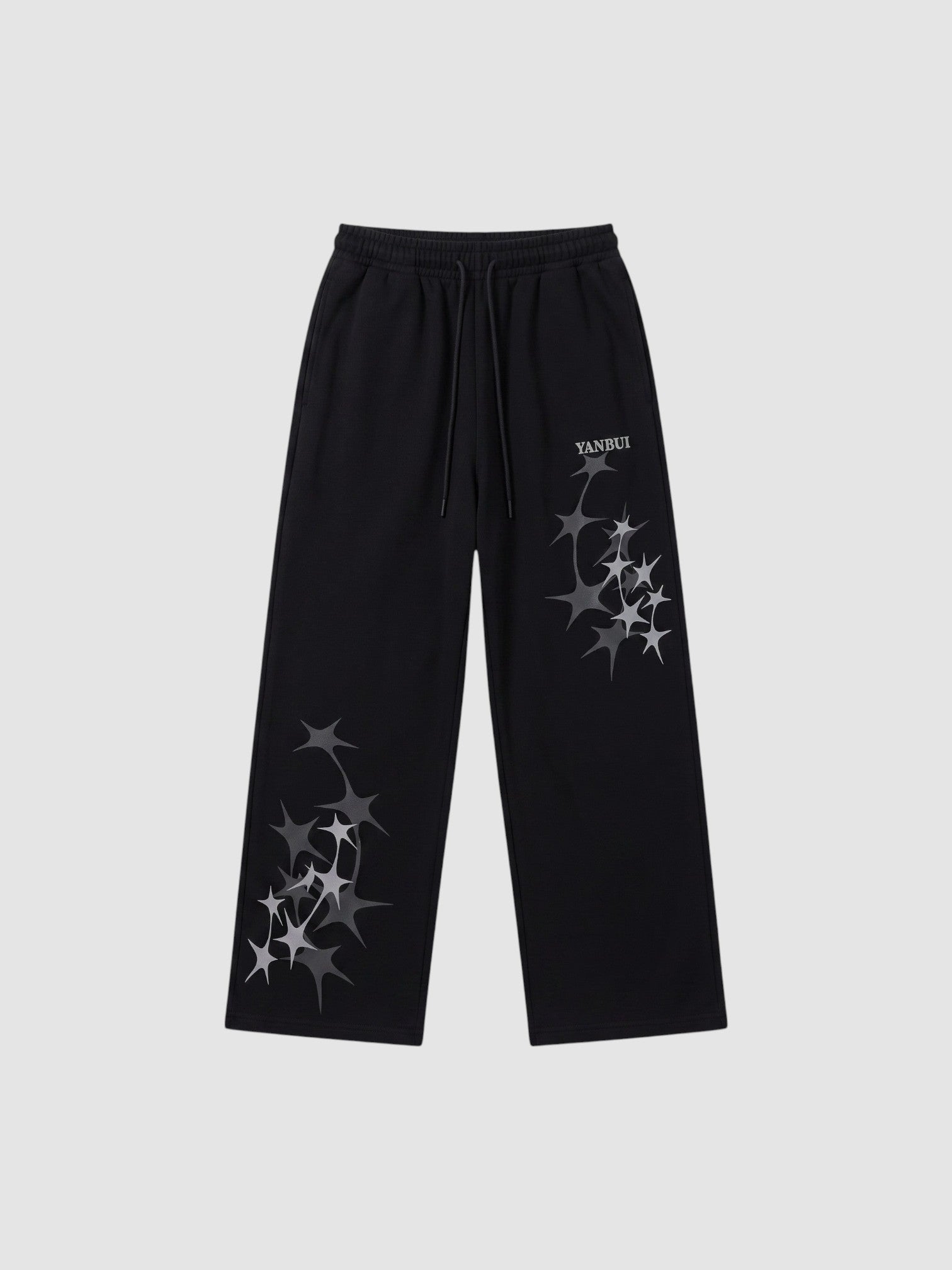 Y2K Studio black wide leg sweatpants featuring grey four-pointed star prints and an elastic drawstring waistband.