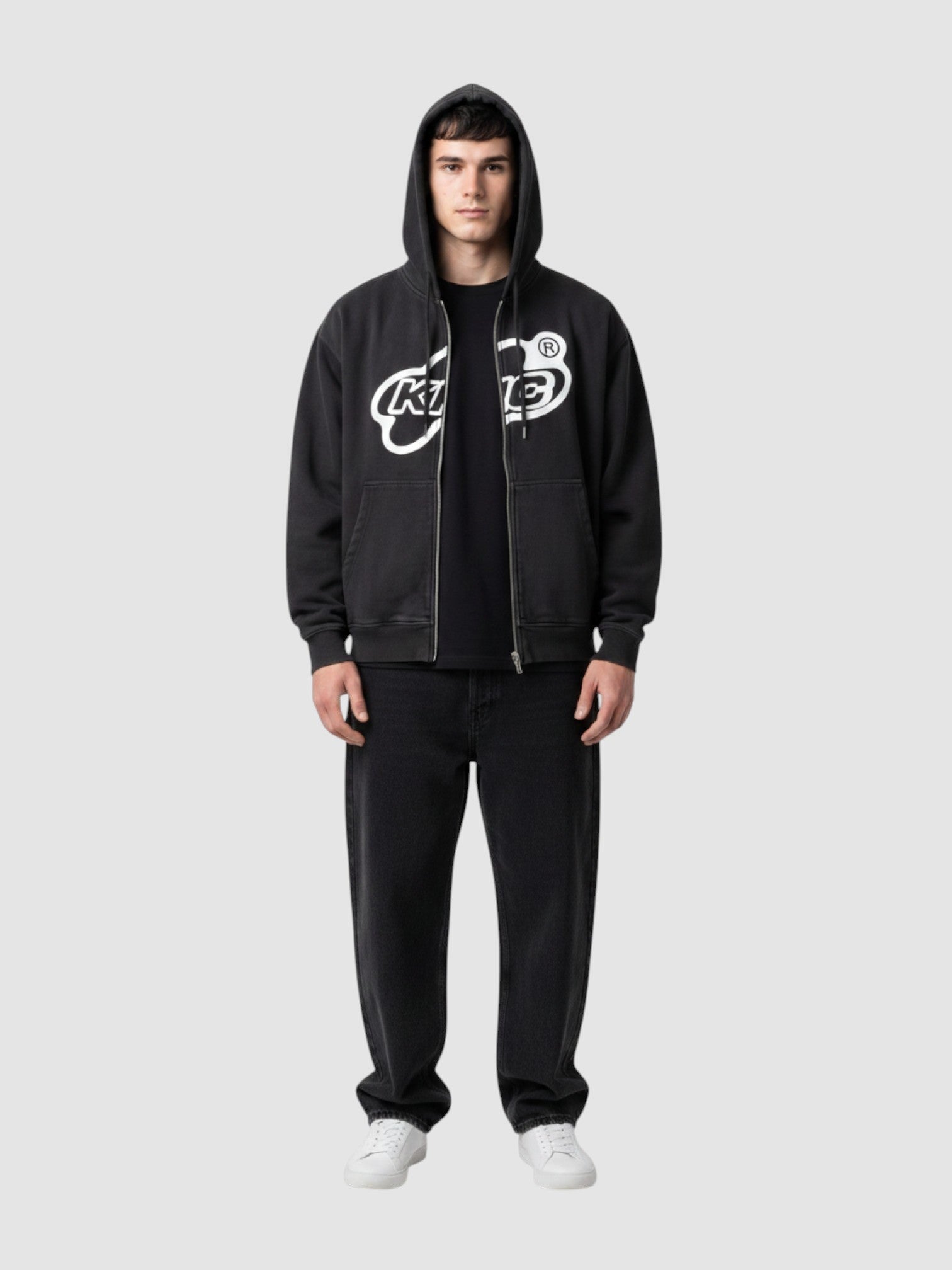 Y2K Studio black zip-up hoodie with white bubble lettering logo, white trim, and oversized fit on a male model.