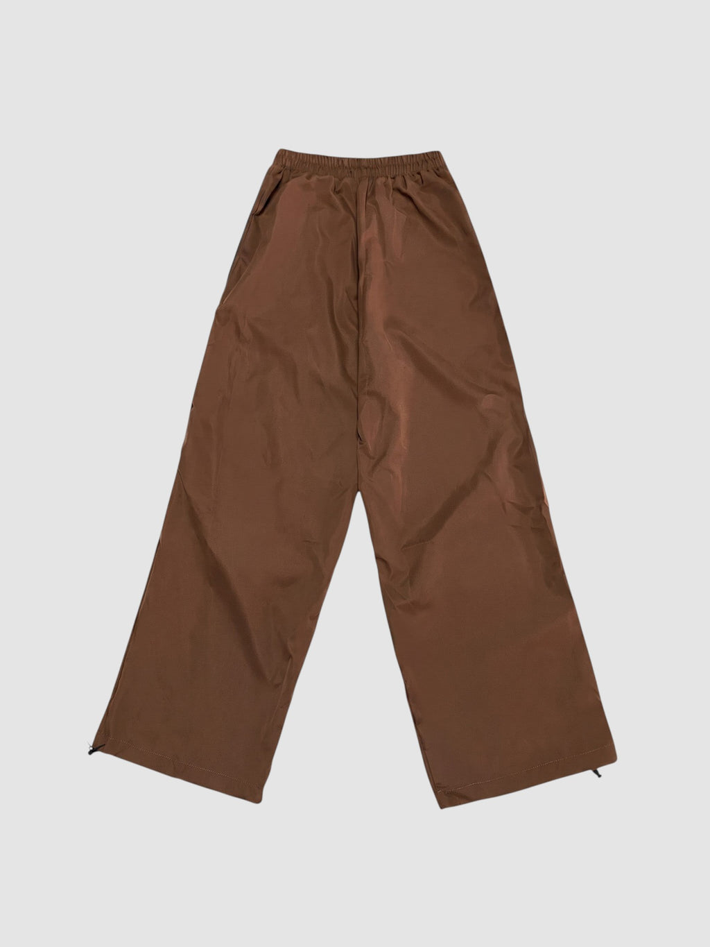 Y2K Studio brown nylon oversized joggers with high elastic waist and wide leg fit on a plain background