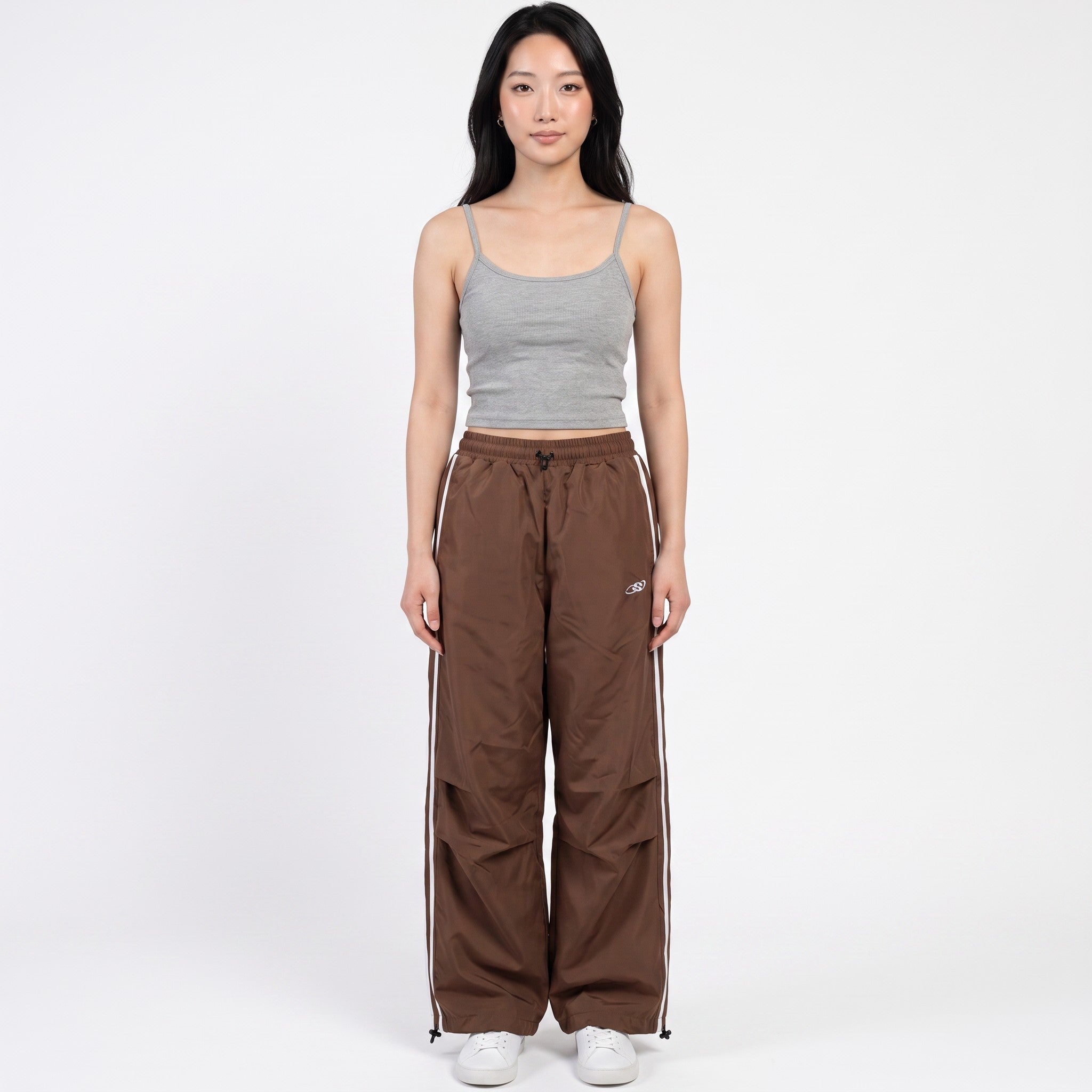 Y2K STUDIO brown oversized nylon joggers with white side stripes and high-waisted fit worn by a model