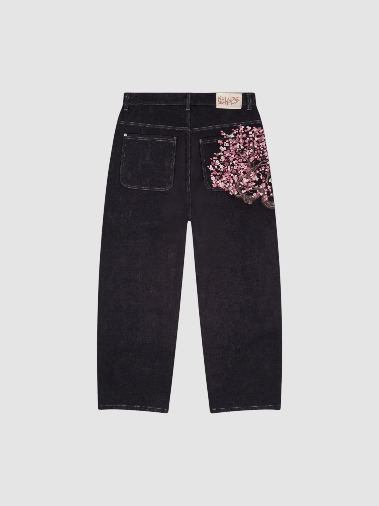 Y2K Studio wide leg dark denim jeans featuring a detailed pink cherry blossom embroidery on the back right pocket.
