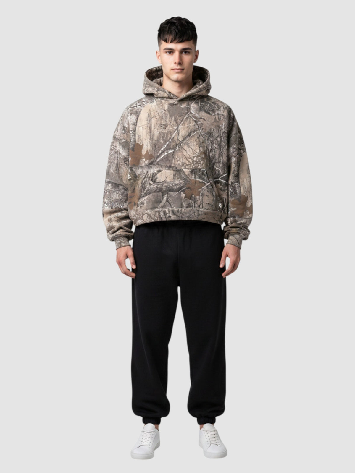 Y2K Studio cropped camouflage hoodie with a tree bark print, oversized boxy fit, and ribbed cuffs on a male model.