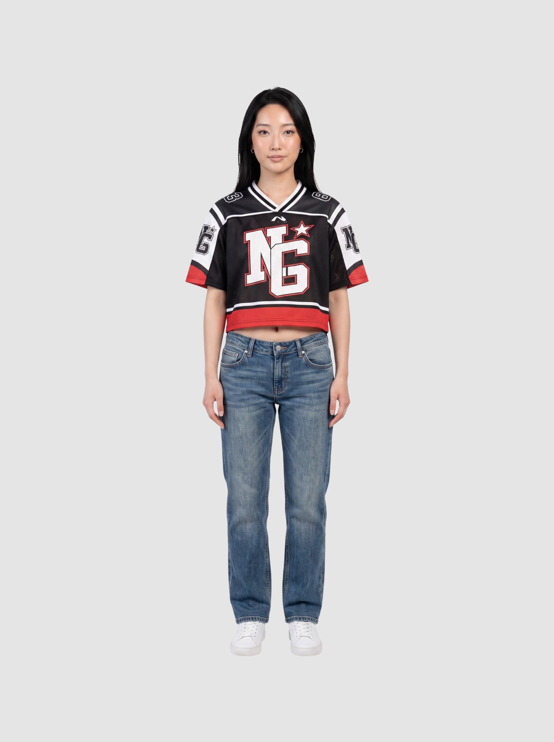 Y2K Studio cropped black mesh football jersey with white shoulder panels, red trim, and graphic monogram print.