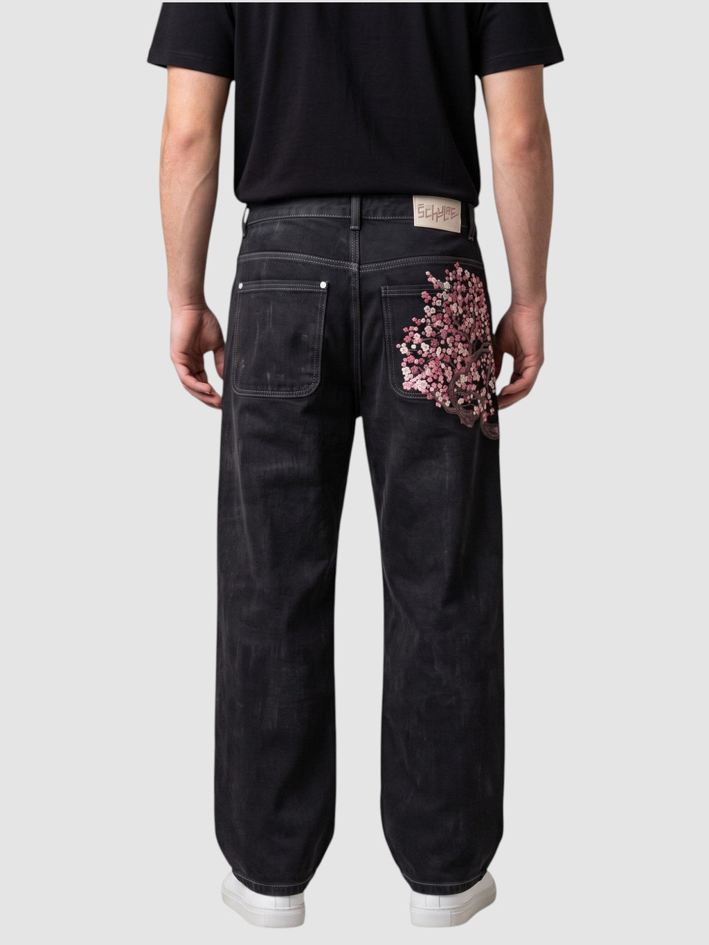 Y2K STUDIO dark denim wide leg jeans with cherry blossom embroidery on the back pocket, worn by a model.