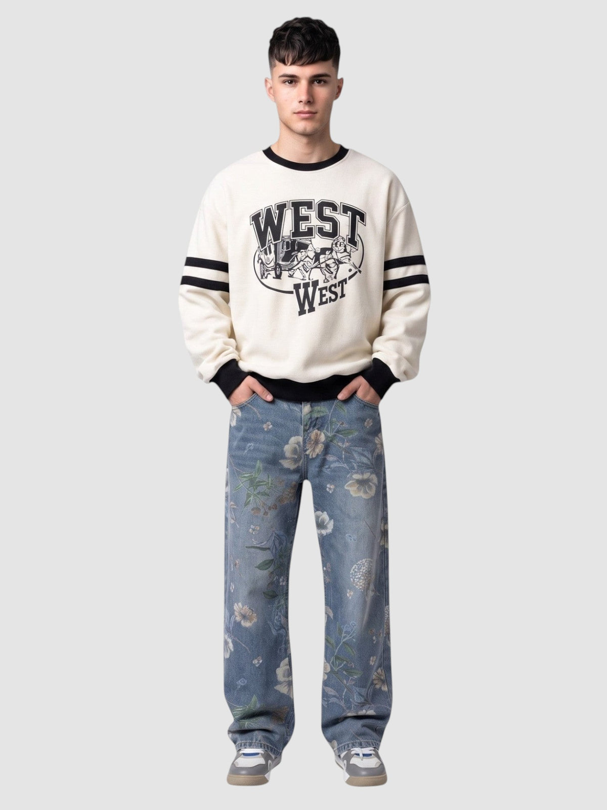 Y2K Studio light blue carpenter jeans with watercolor floral print worn by a man in a cream graphic sweatshirt.