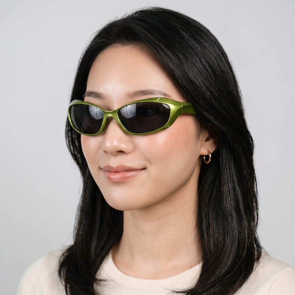Y2K STUDIO green wraparound futuristic sunglasses with dark lenses worn by a woman against a neutral background