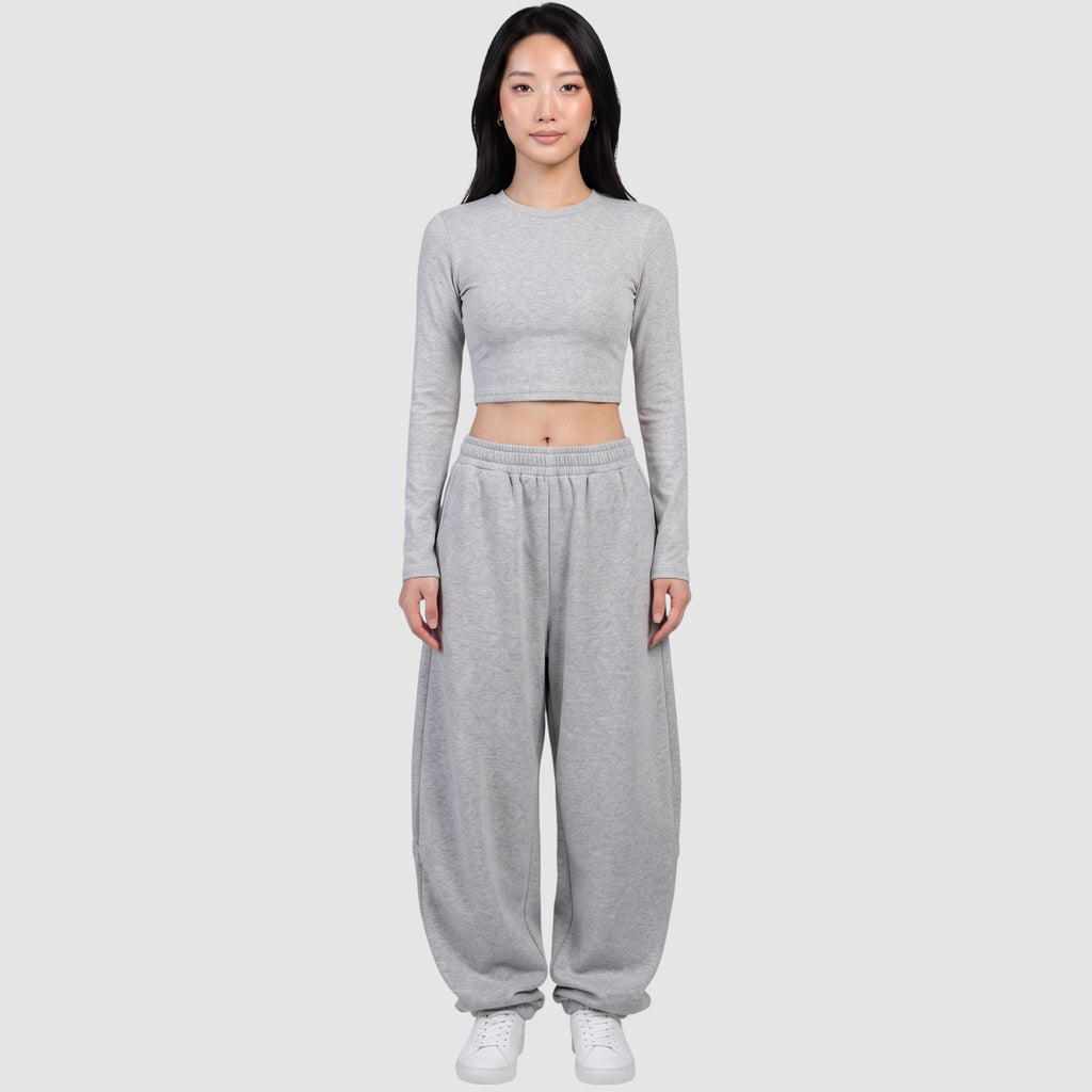 Y2K STUDIO grey barrel leg sweatpants with a high elastic waist and relaxed fit worn by a model with a crop top.
