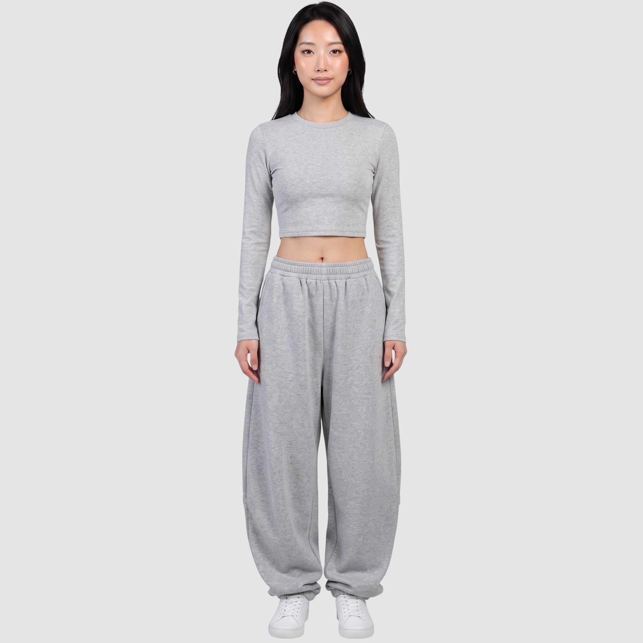 Y2K STUDIO grey barrel leg sweatpants with a high elastic waist and relaxed fit worn by a model with a crop top.