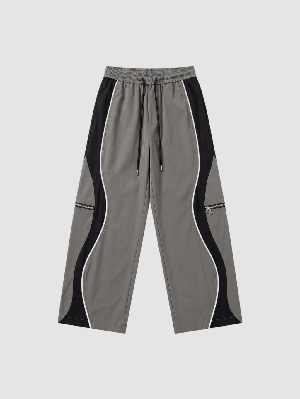 Y2K STUDIO grey and black panelled Y2K trousers with white piping, decorative zippers, and adjustable ankle cords.