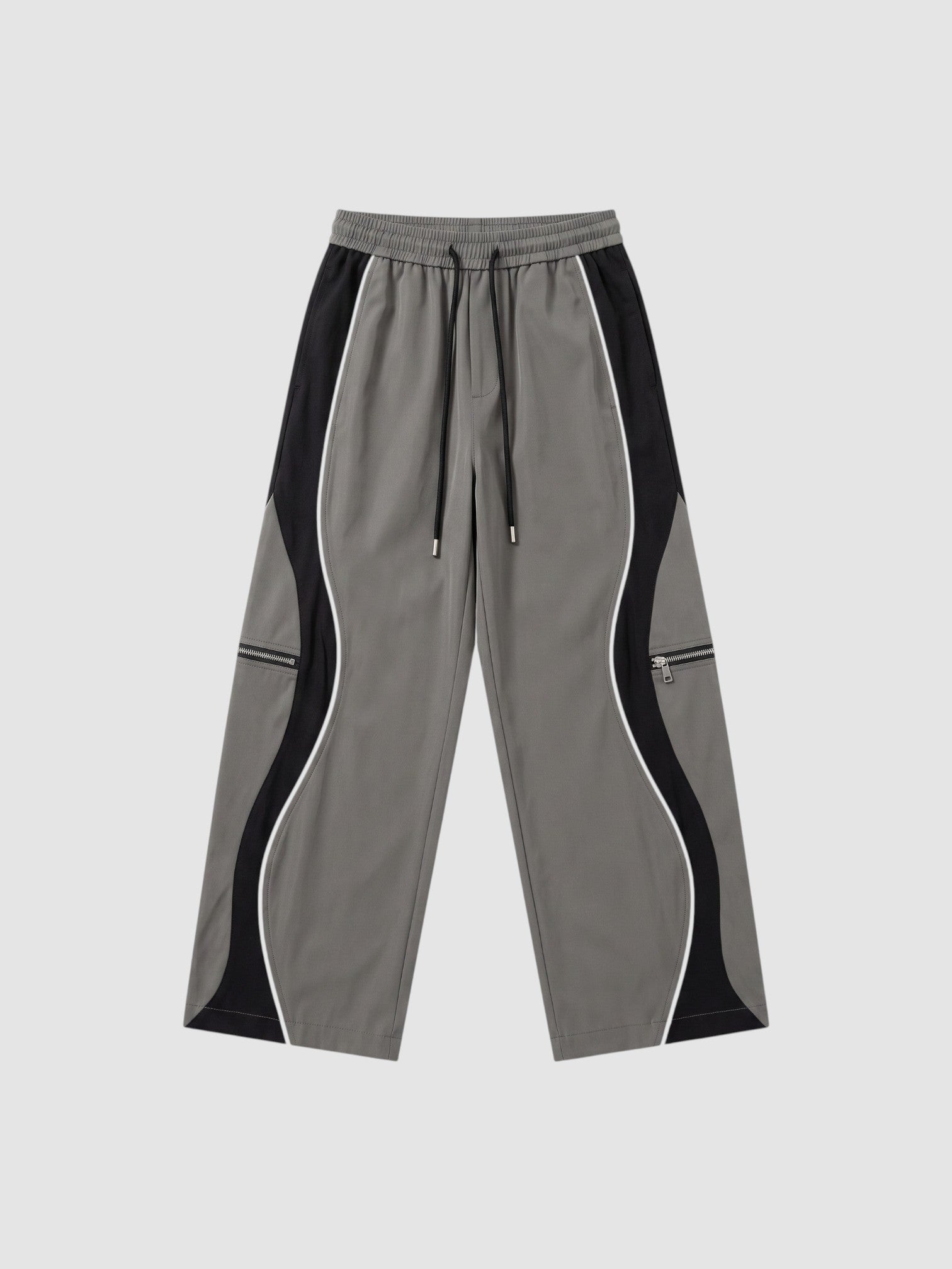 Y2K STUDIO grey and black panelled Y2K trousers with white piping, decorative zippers, and adjustable ankle cords.