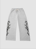 Y2K Studio grey heather wide-leg joggers featuring black tribal graphic prints on the sides and an elastic waistband.