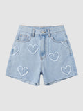 Y2K Studio high-waisted light blue denim shorts featuring frayed heart appliqués and a raw hem.