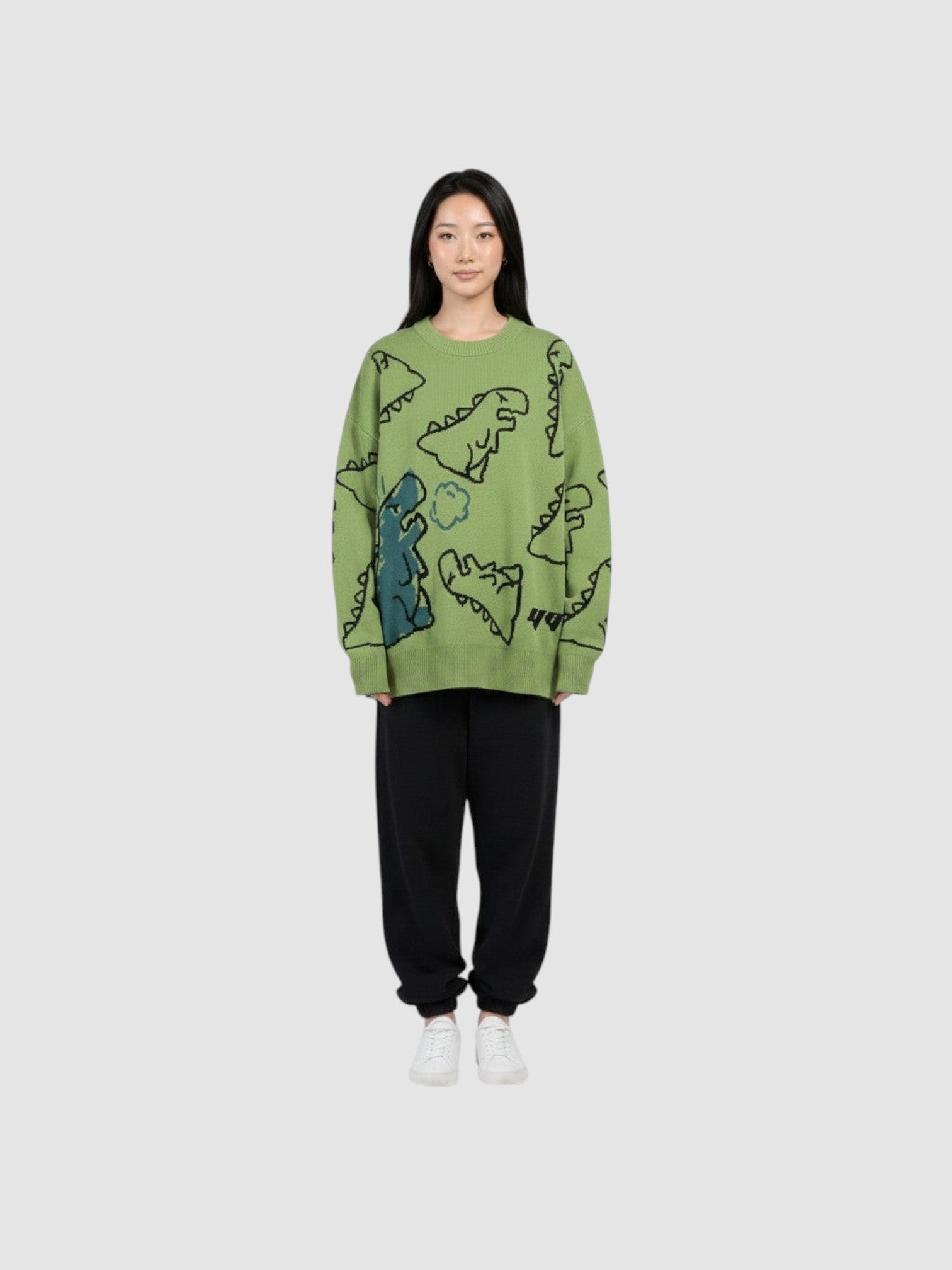 Y2K STUDIO khaki knit sweater featuring a playful cartoon dinosaur pattern, crew neck, and long sleeves on a model.