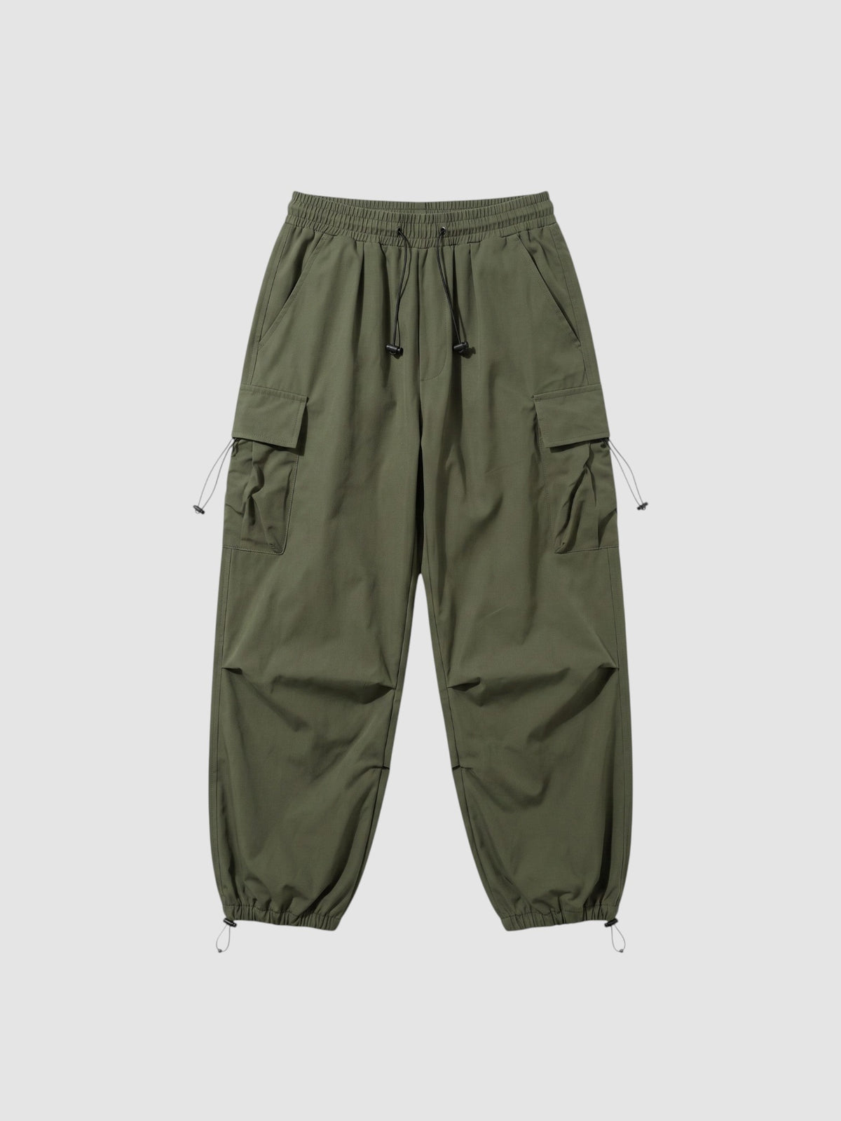 Y2K Studio olive green parachute cargo pants with elastic waistband, side flap pockets, and adjustable leg cords.