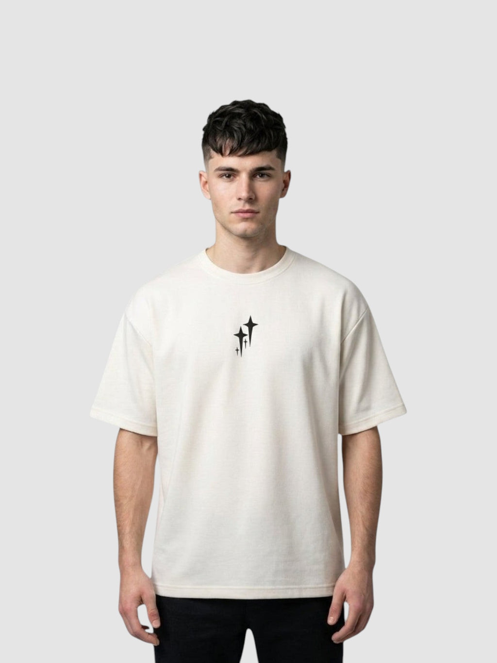 Y2K Studio oversized cream t-shirt with chrome star graphic, ribbed crew neck, and drop shoulders on a male model.