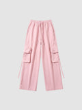 Y2K Studio powder pink parachute cargo pants with wide legs, elastic waist, drawstring, and side flap pockets.