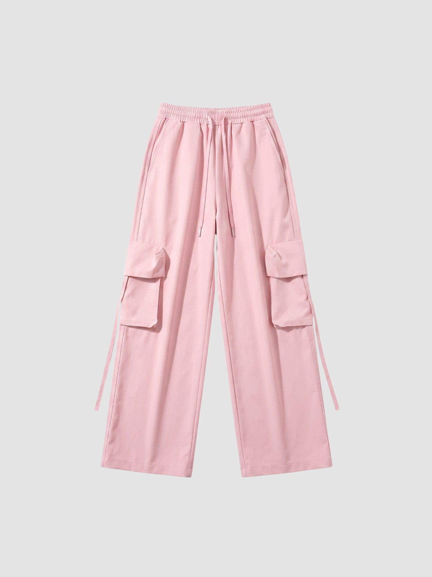 Y2K Studio powder pink parachute cargo pants with wide legs, elastic waist, drawstring, and side flap pockets.