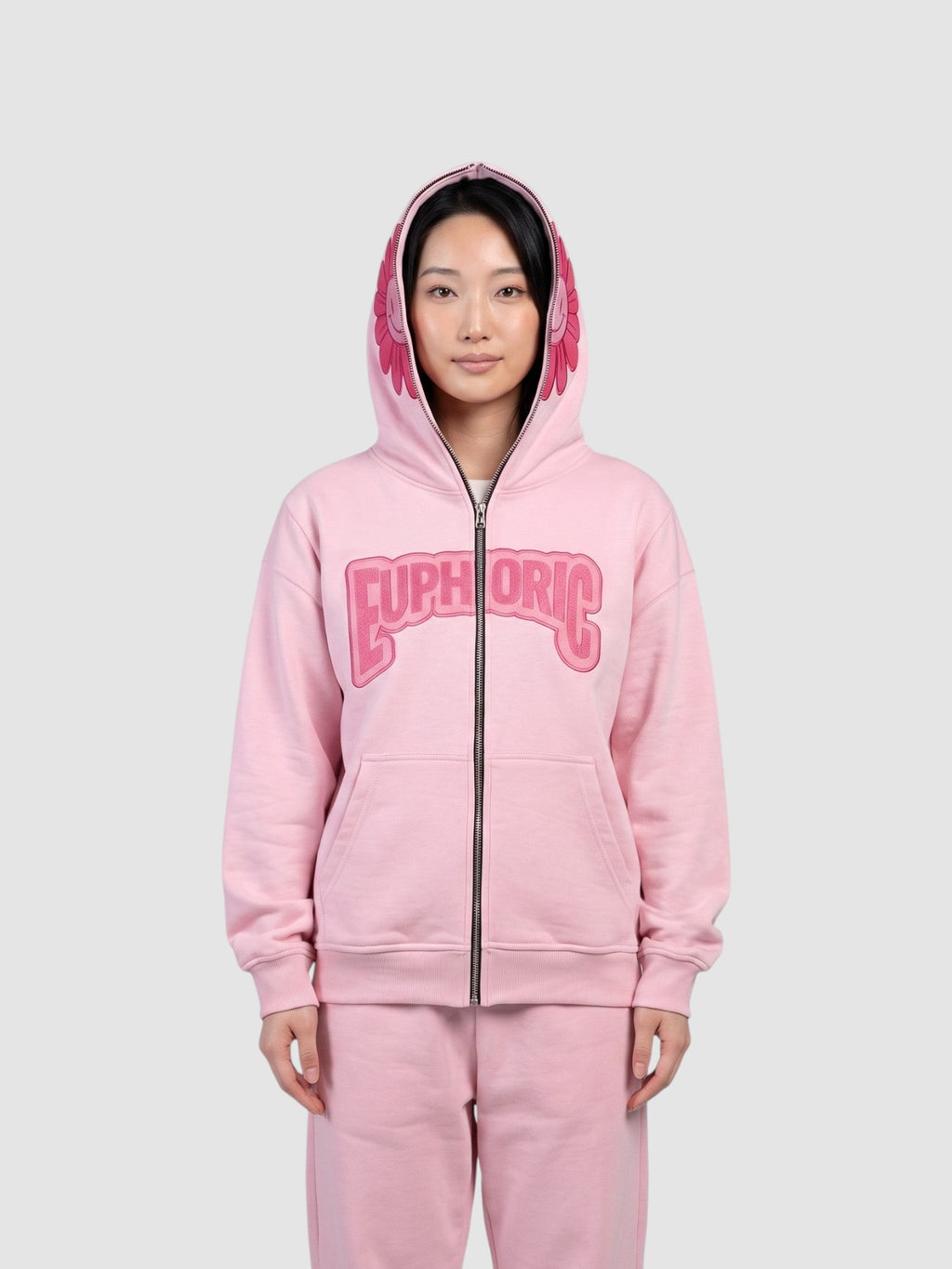 Y2K Studio pale pink zip-up hoodie featuring a bubble letter graphic and a smiley flower detail on the hood.
