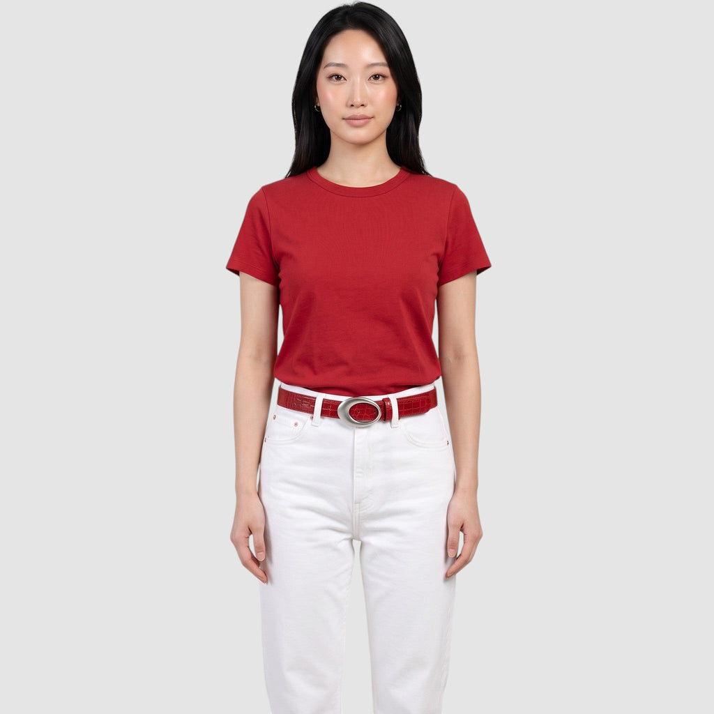 Y2K STUDIO red faux crocodile leather belt with a silver oval buckle worn by a model in a red t-shirt and white jeans