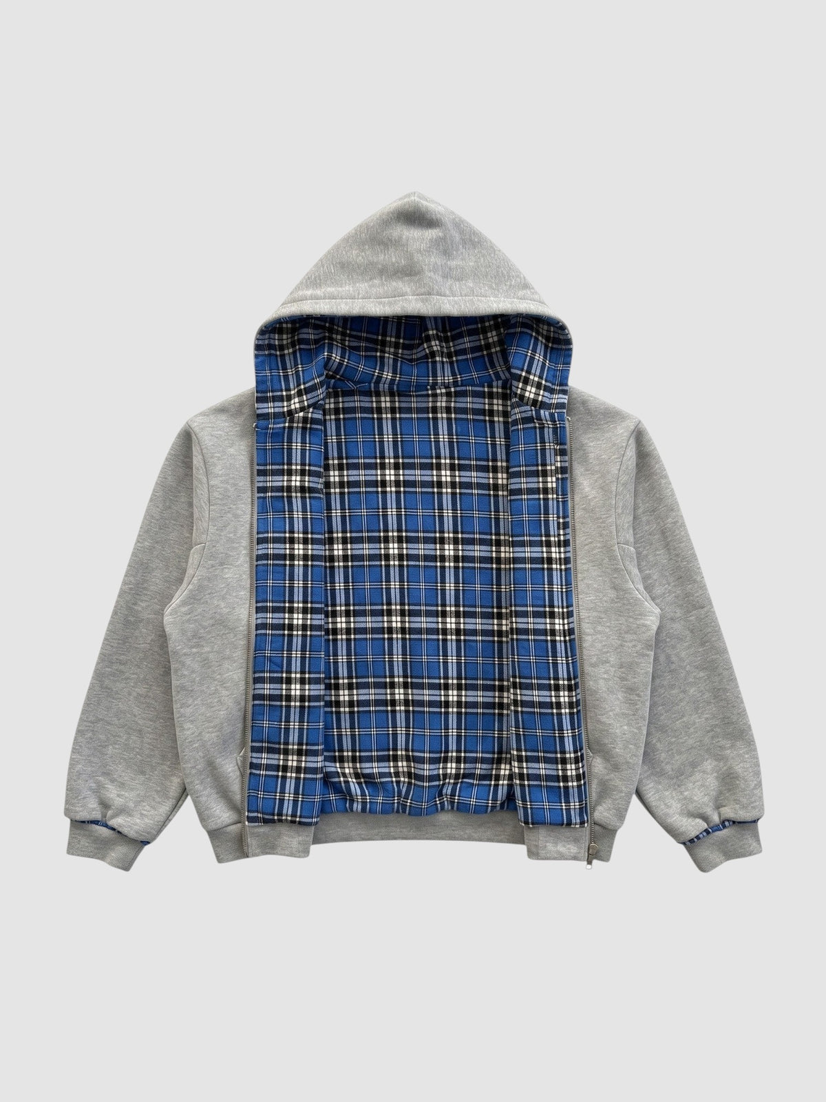 Y2K STUDIO reversible zip-up hoodie featuring a grey cotton fleece exterior and a blue tartan plaid interior lining.