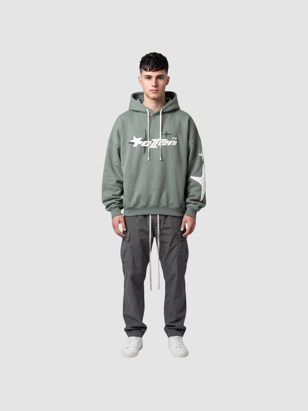 Y2K Studio sage green oversized hoodie with white star graphic and lettering, worn by a male model with cargo pants.
