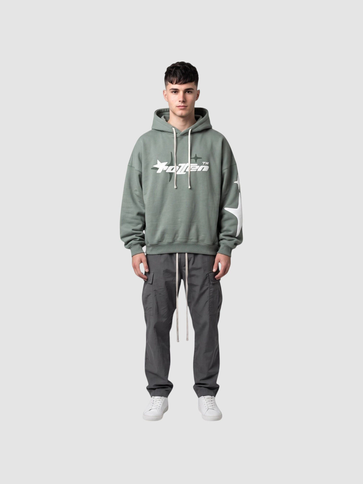 Y2K Studio sage green oversized hoodie with white star graphic and lettering, worn by a male model with cargo pants.