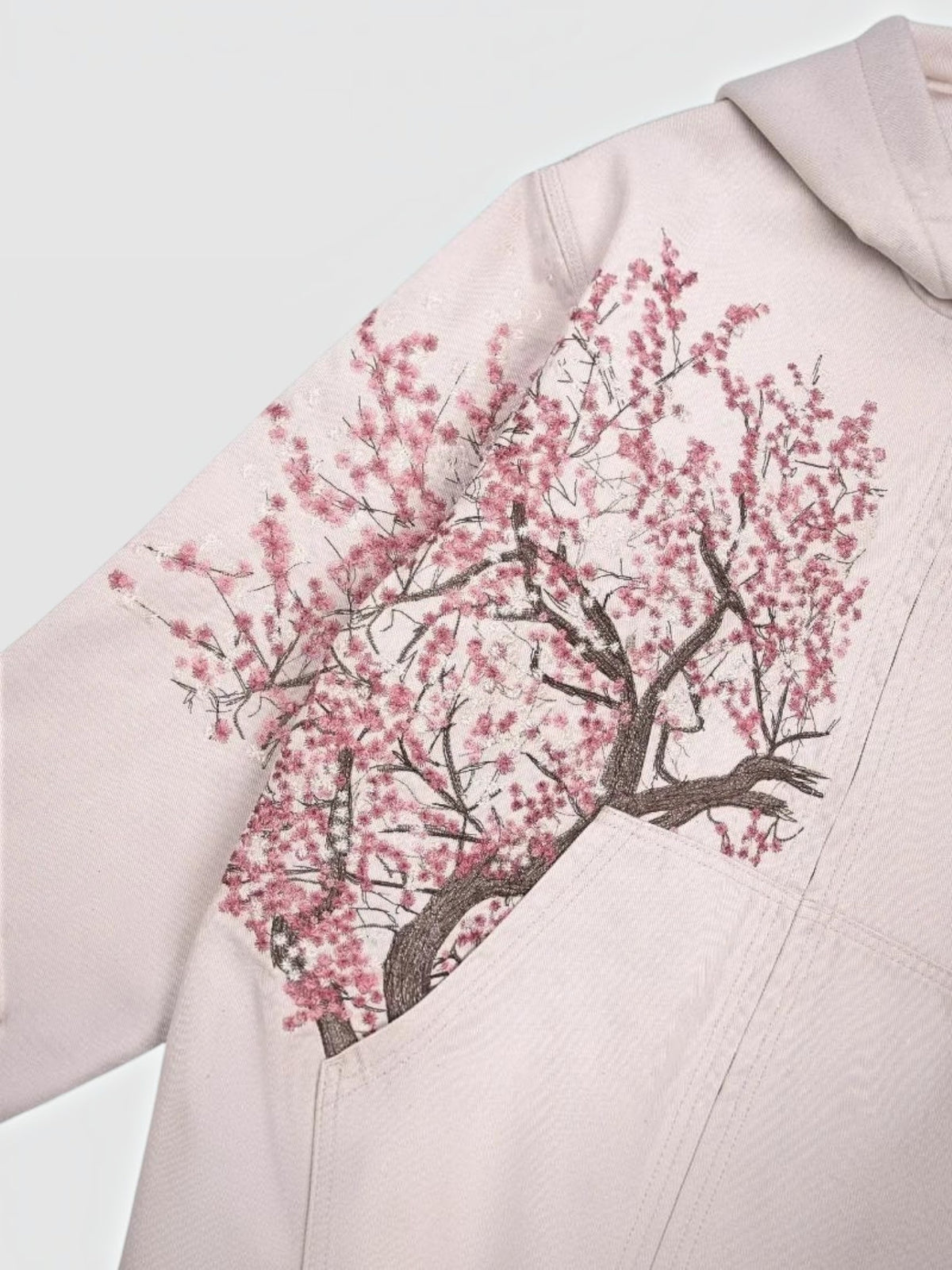 Y2K Studio Sakura zip-up hoodie in faded powder pink cotton with an asymmetrical cherry blossom branch print