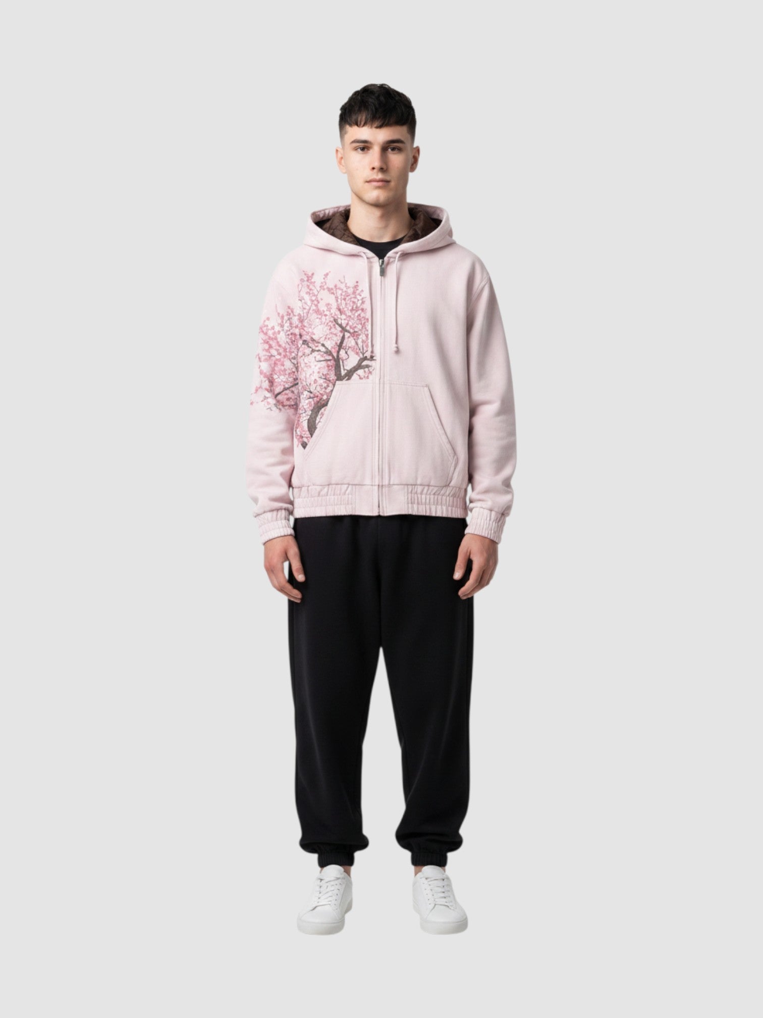 Y2K Studio Sakura zip-up hoodie in faded powder pink cotton with an asymmetrical cherry blossom print on the side.