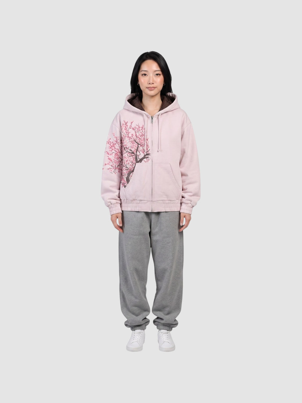 Y2K Studio Sakura zip-up hoodie in faded powder pink cotton with an asymmetrical cherry blossom print and boxy fit.