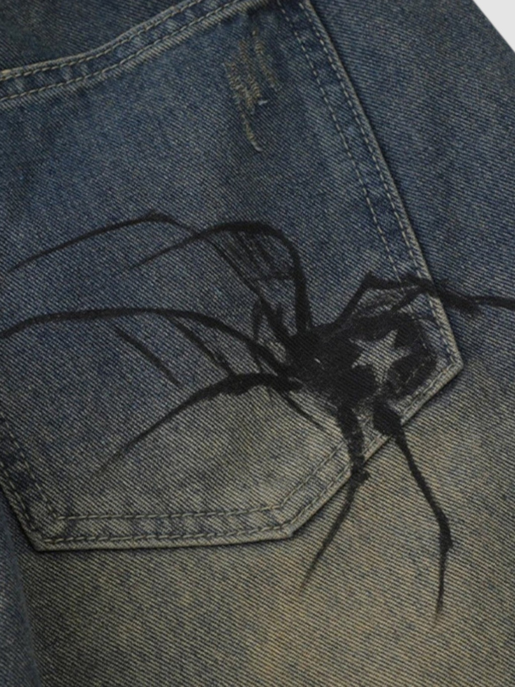 Y2K STUDIO blue distressed denim jorts featuring a detailed black spider graphic printed on the back pocket