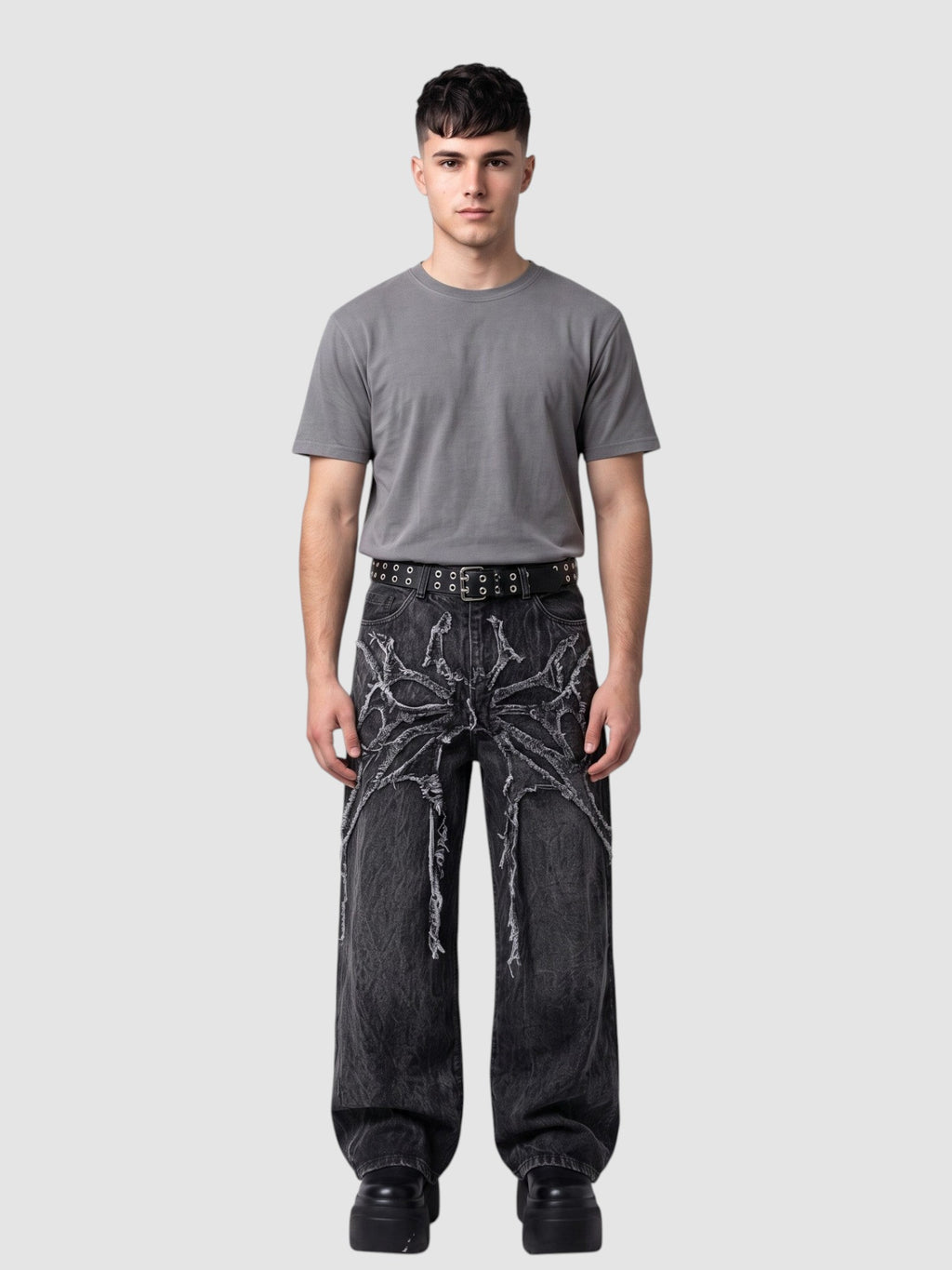 Y2K Studio wide-leg acid wash black denim jeans with raw-edge spiderweb fabric appliqués radiating from the waist.