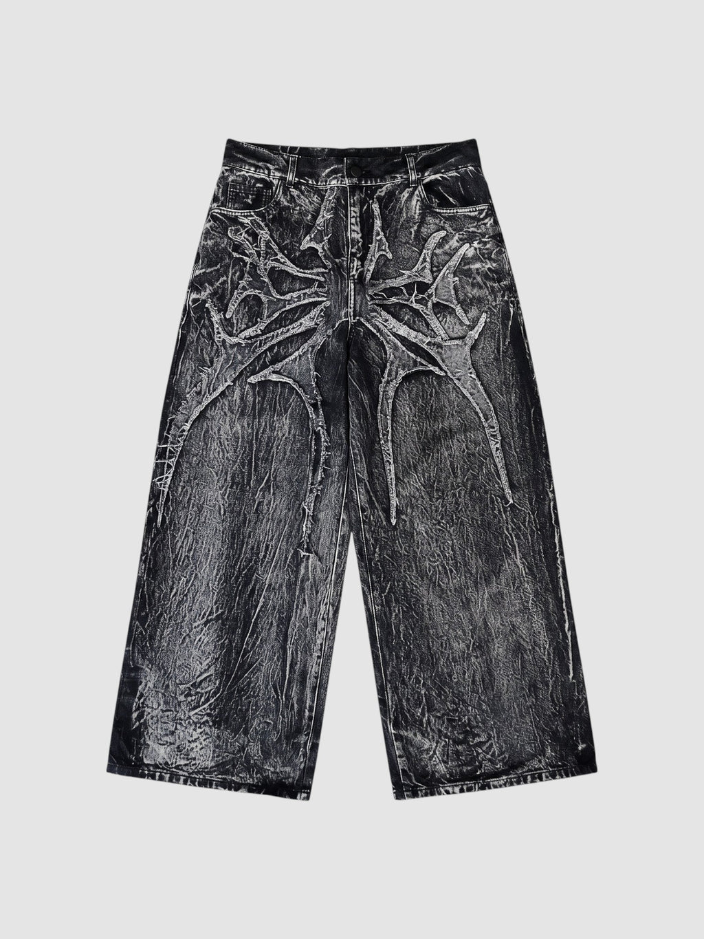 Y2K Studio wide-leg denim jeans in acid wash black and grey with raw-edge spiderweb fabric appliqués.