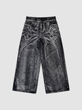 Y2K Studio wide-leg denim jeans in acid wash black and grey with raw-edge spiderweb fabric appliqués.